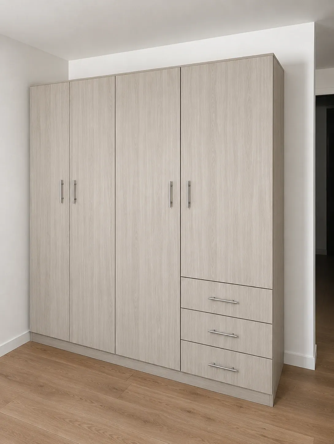 A four-door pale oak wardrobe built floor to ceiling against a bedroom wall, three drawers under the right-hand door