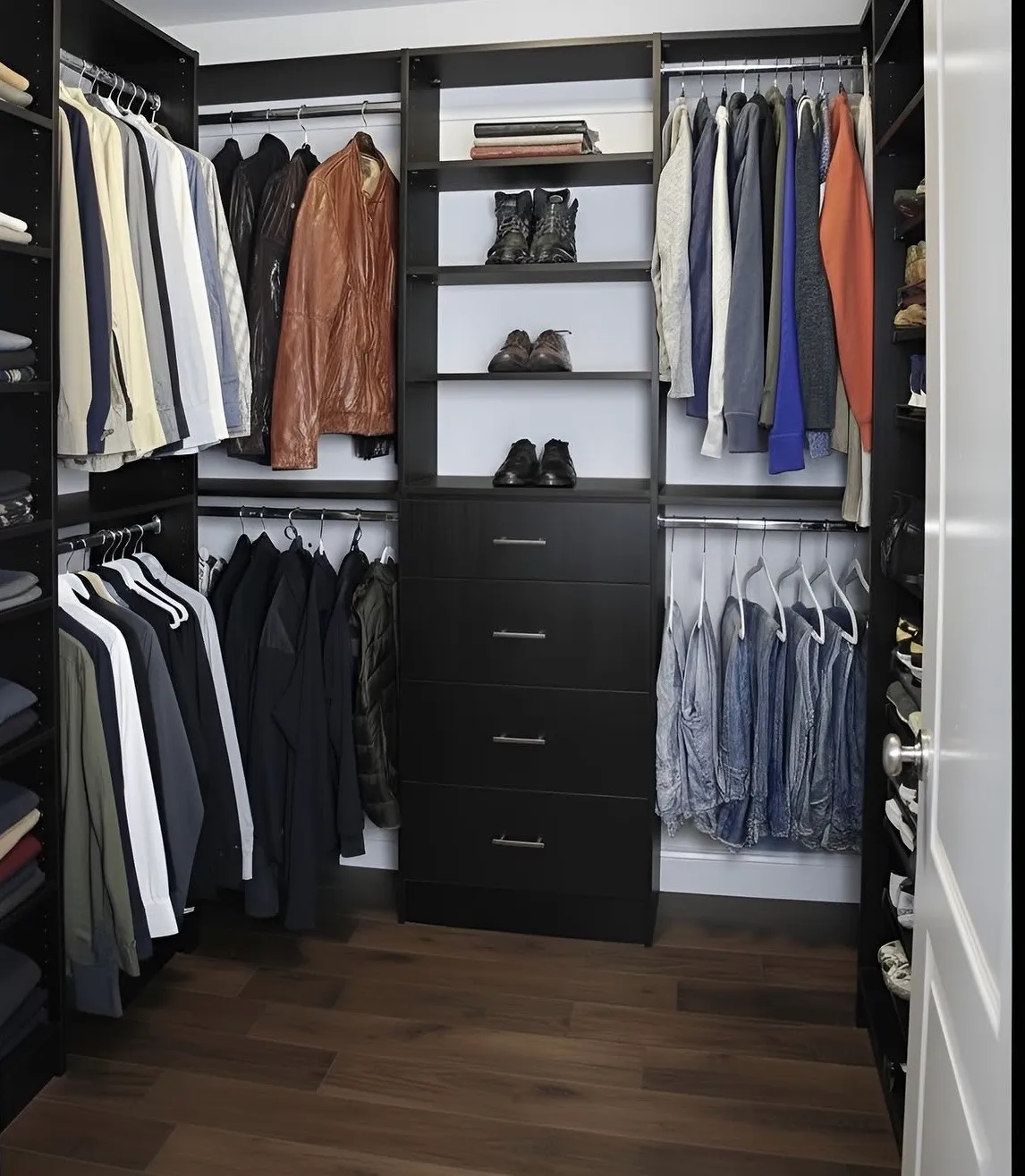 An espresso walk-in closet with double hanging on three walls, open shelving down the middle and a drawer bank below